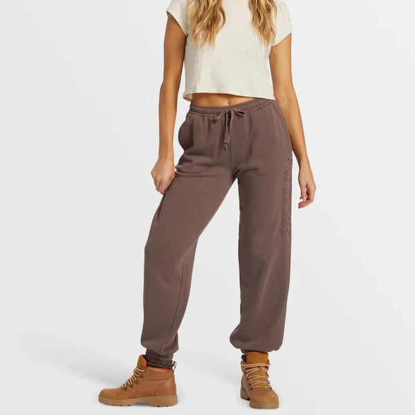 front view of the model wearing the palmin elastic waist joggers. shows the elastic drawcord closure. also shows the elastic leg opening, the on seam pockets, and the logo on the side. 