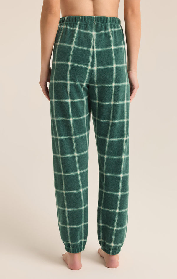 back view of the model wearing the plaid joggers. shows the ankle length. also shows the mid rise, the plaid detailing. 