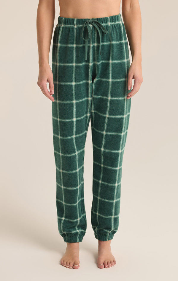 front view of the model wearing the plaid joggers. shows the tie waist. also shows the jogger style bottom, ankle length, and the plaid detailing. 