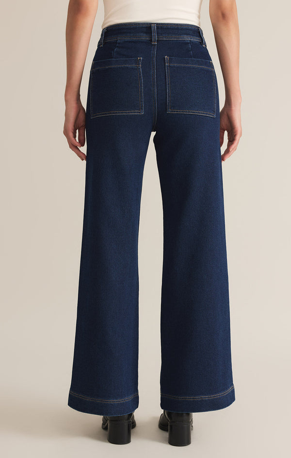 back view of the model wearing the rilynn wide leg denim trousers. shows the back pockets, also shows the high rise, the belt loops and the wide legs. 