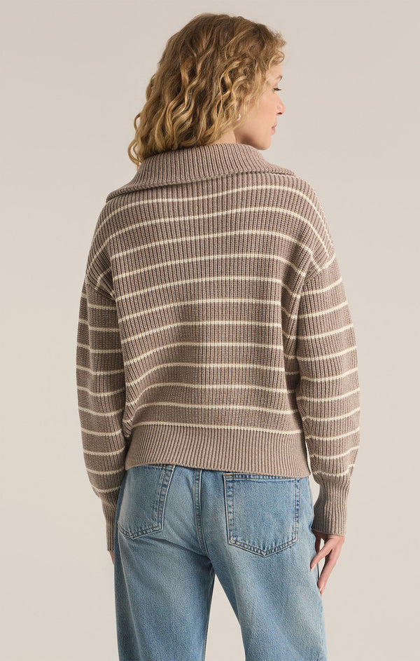 back view of the model wearing the villa half zip sweater. shows the white stripes. also shows the ribbed detailing and the ribbed detailing. 