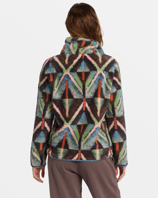 back view of the model wearing the switchback mock neck fleece. shows the multi color design. also shows the mock neckline, and the relaxed fit. 