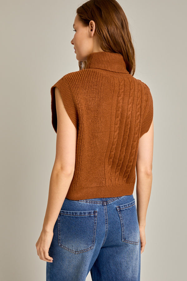 back view of the model wearing the sonya turtleneck sweater vest. shows the cap sleeveless sleeves. also shows the turtleneck, the ribbed detailing and the beautiful color caramel. 