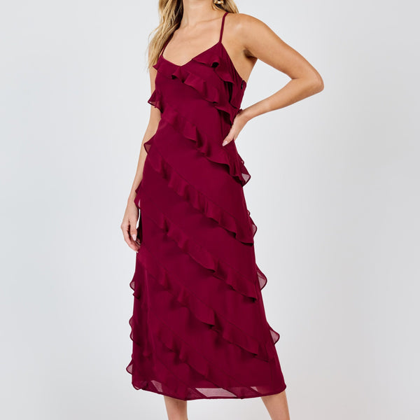 front view of the model wearing the all invited ruffle maxi dress. shows the v neckline. also shows the ruffle design, the side sipper closure and the midi length. 