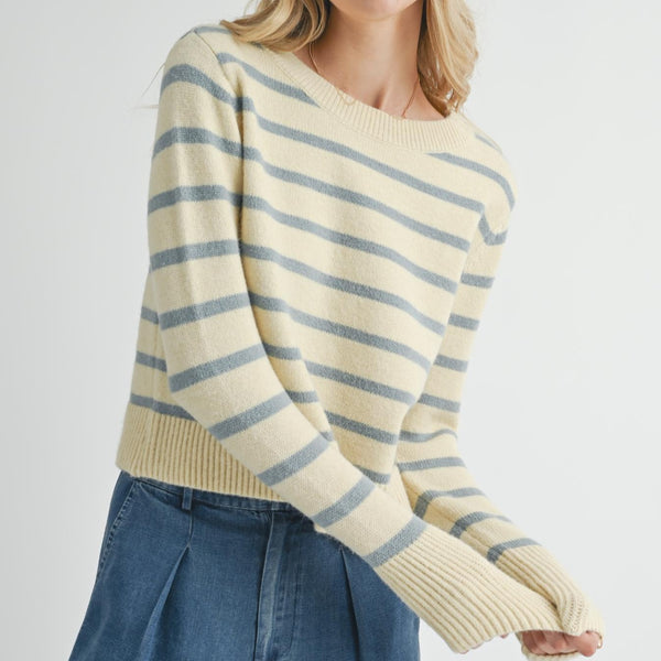 front view of the model wearing the sheri striped sweater. shows the crew neckline. also shows the ribbed detailing on the cuffs, neckline and the bottom hem, the blueish striped pattern and the waist length. 