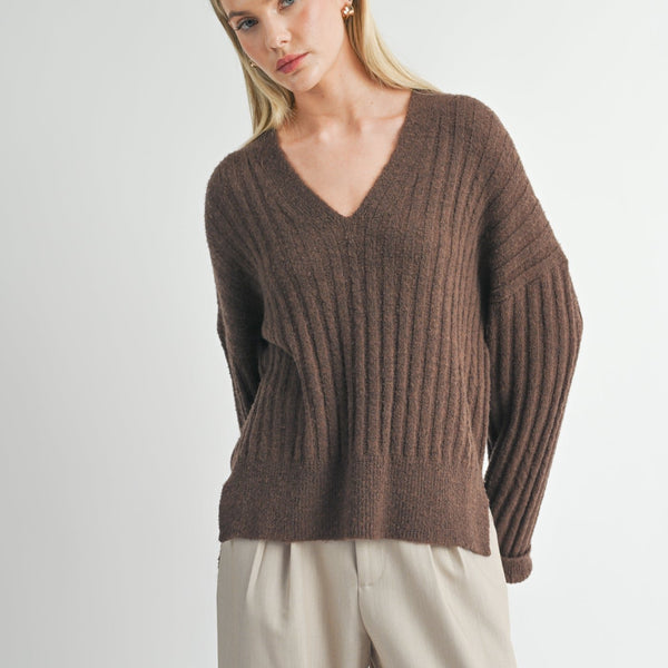 front view of the carli v neck pullover. shows the v neckline. also shows the dropped shoulders, the ribbed detailing and the oversized fit. 