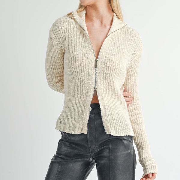 front view of the model wearing the tori ribbed zip up cardi. shows the zipper closure. also shows the collar, the ribbed detailing and fitted style. 