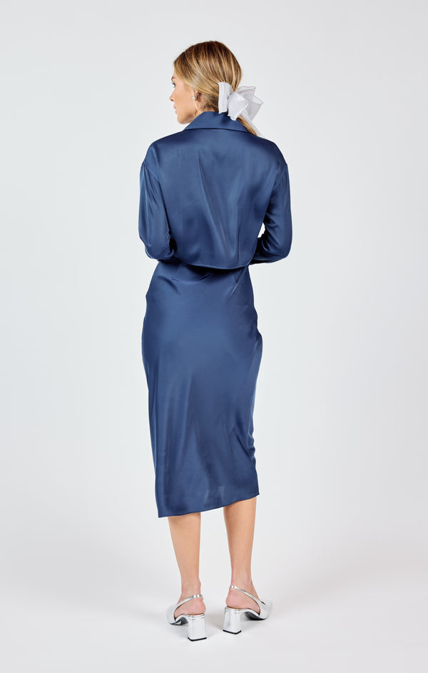 back view of the model wearing the last night shirt open back midi dress. shows the open back. also shows the navy color, the color and the midi length. 