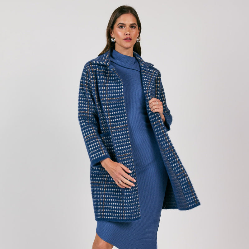 front view of the model wearing the marceau houndstooth coat. shows the traditional collar. also shows the front patch pockets, the mid length and the houndstooth design. 