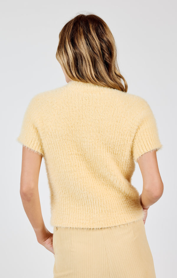 back view of the model wearing the rudy ribbed short sleeve sweater. shows the beautiful lemon color. also shows the crew neckline, the short sleeves and the ribbed detailing. 