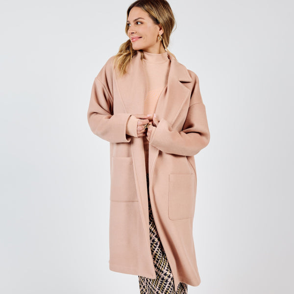 front view of the model wearing the hayley open coat. shows the open front. also shows the front patch pockets, the collar and the mid length. also shows the rose color. 