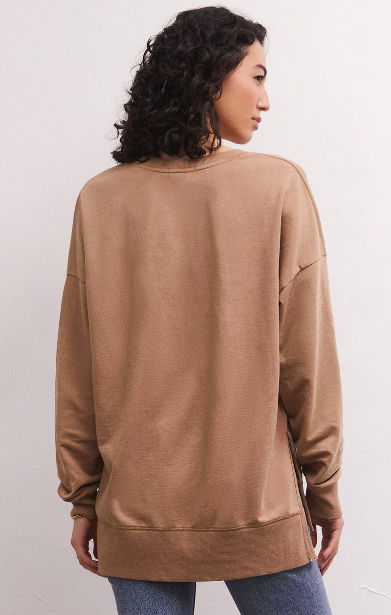 Back view of model wearing weekender. Shows the long sleeves. Also shows the hi lo hem and the beautiful color mink .