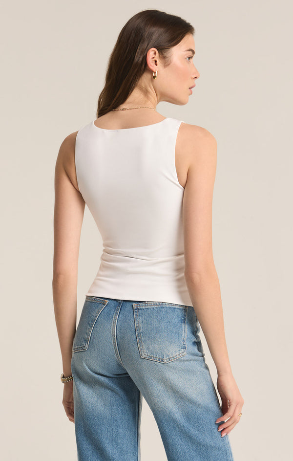 back view of the model wearing the avala v neck so smooth top in white. shows the fitted look. also shows that the top is sleeveless and tuck-able. 