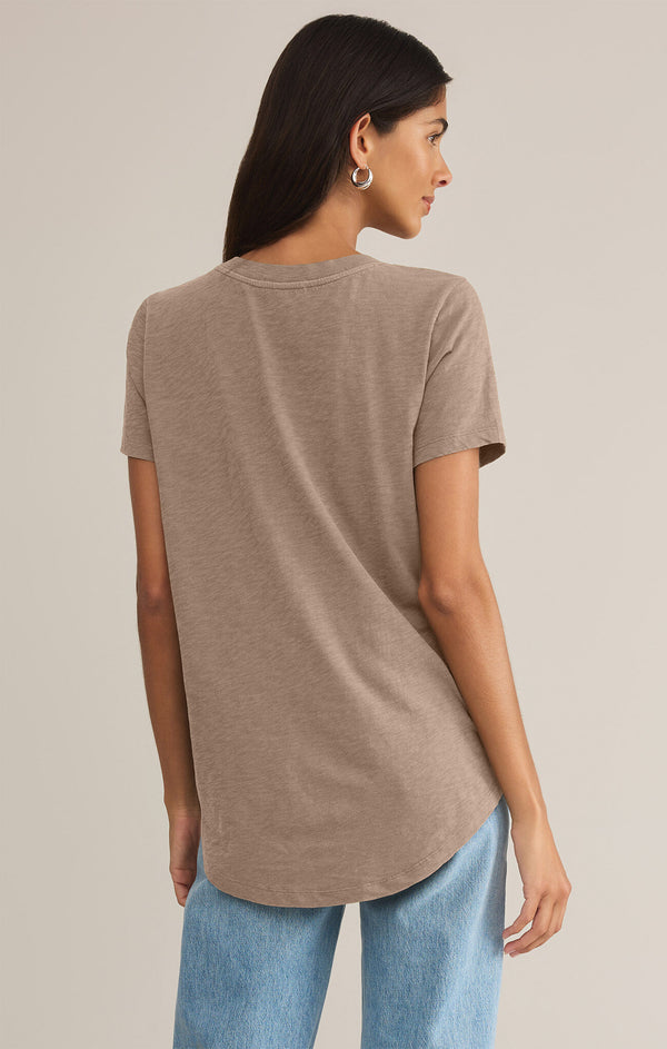 back view of the model wearing the asher v neck tee. shows the curved bottom hem. also shows the short sleeves and the heather taupe color. 