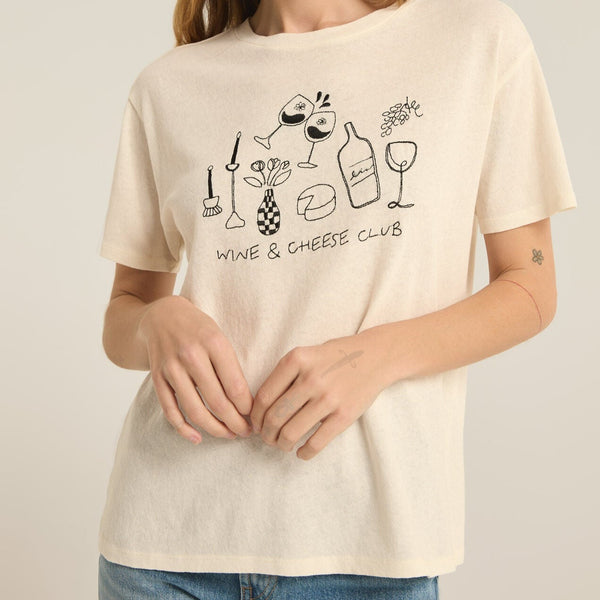 front view of the model wearing the wine & cheese pacific tee. shows the relaxed fit. also shows the crew neckline, the embroidered wine and cheese design, and the short sleeves. 